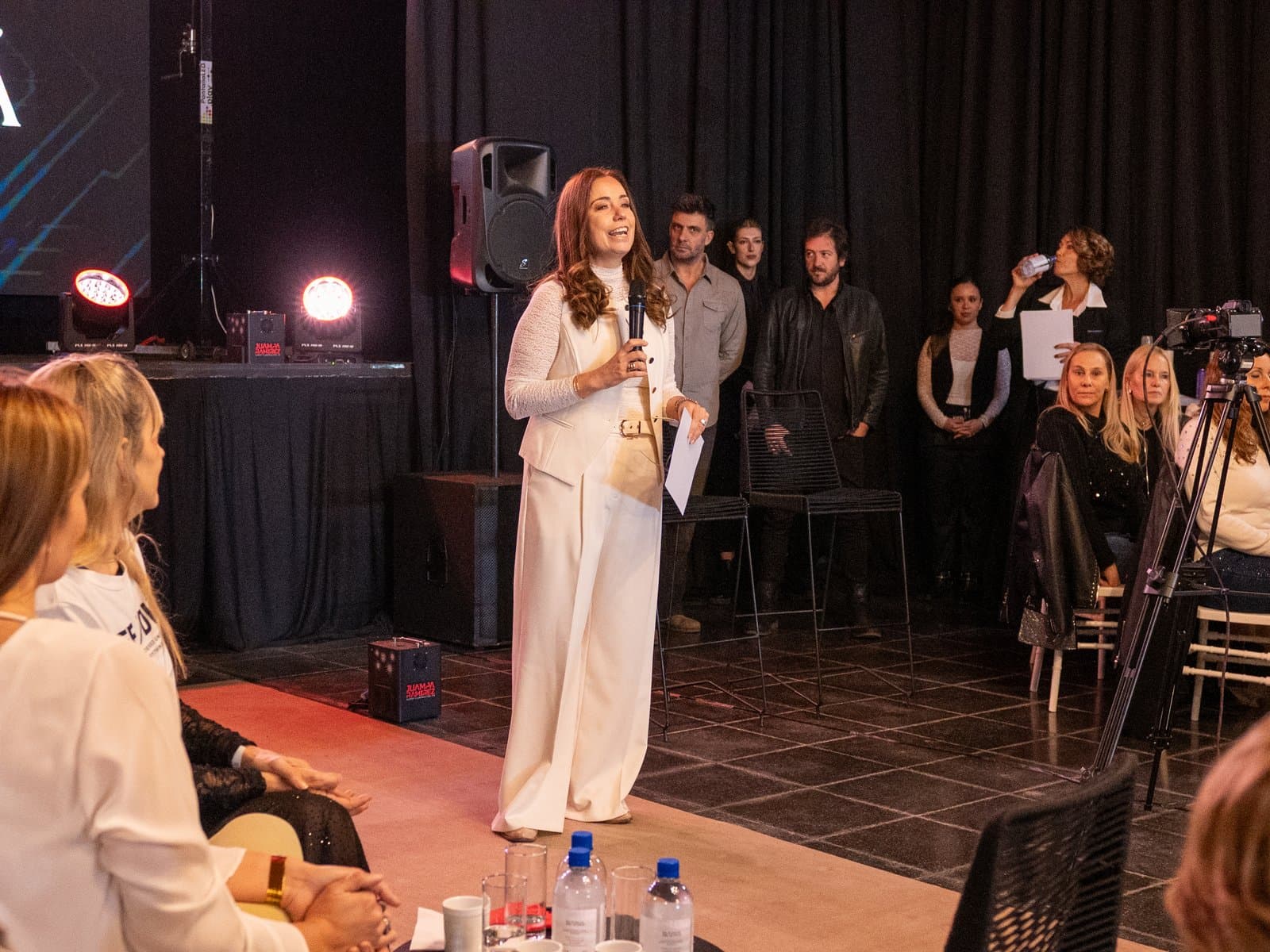Presentación con micrófono frente al público sentado en el Teatro Cristal, durante IMAGINÁ